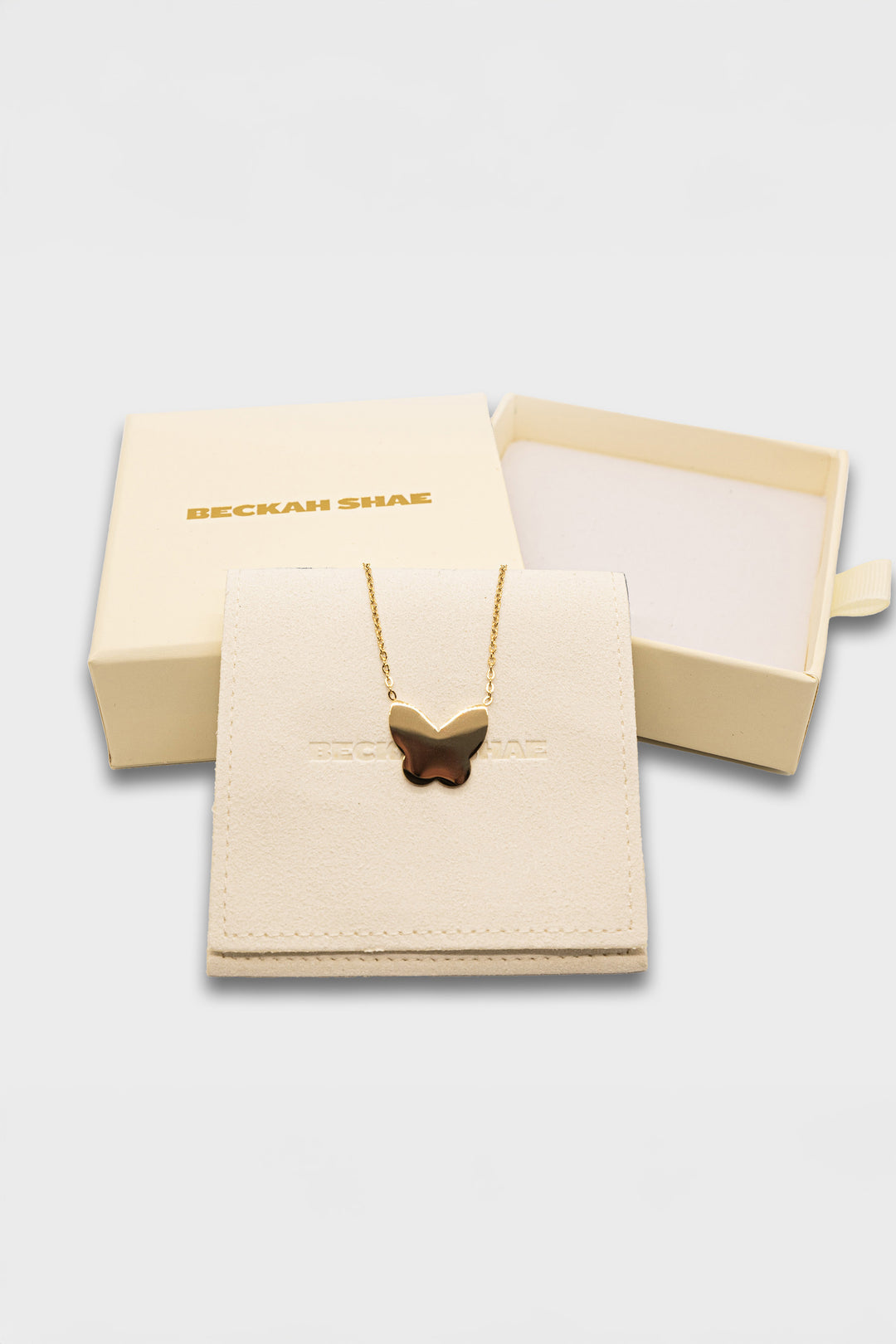 Butterfly pendant necklace presented in Beckah Shae branded cream jewelry box and soft sleeve pouch.