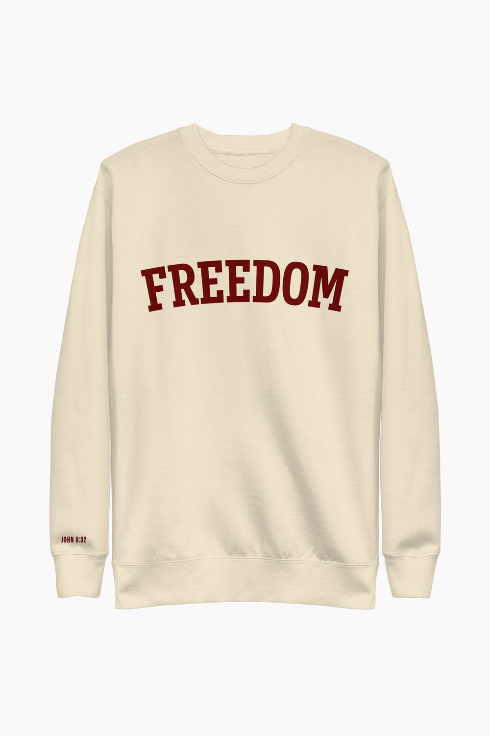 Flat-lay of FREEDOM collegiate sweatshirt in cream with bold burgundy letters and Bible verse on cuff.