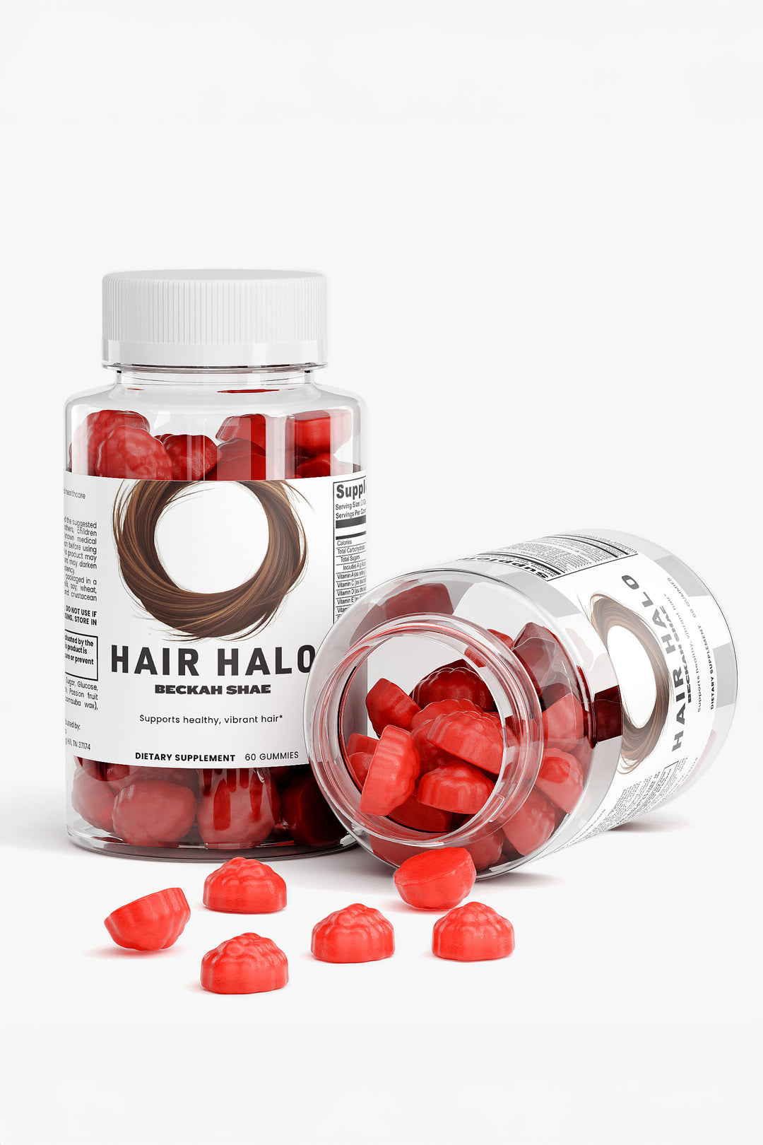 Two Hair Halo bottles with bright red fruit-shaped gummies pouring out onto a clean white surface.
