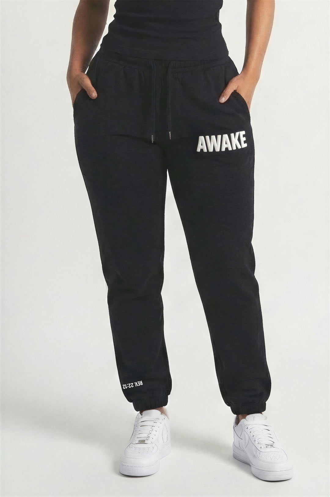 Person wearing black 'AWAKE' sweatpants on a white background